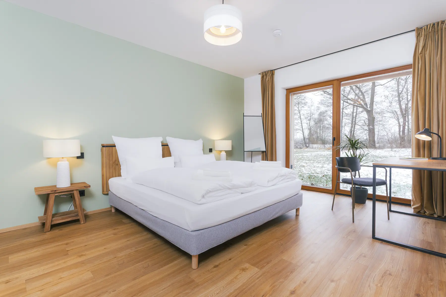 Ruhiges Schlafzimmer der Wohnung Sonnenuntergang mit Doppelbett und Blick in den Garten
