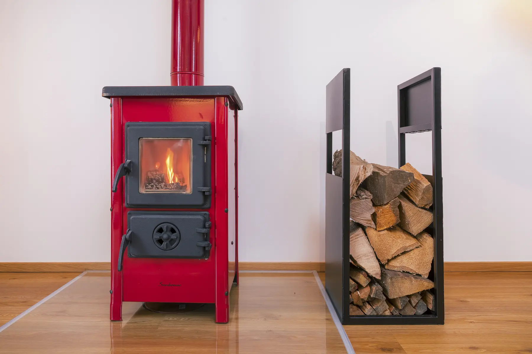 Brennender Kaminofen mit Feuerholz in der Wohnung Sonnenuntergang