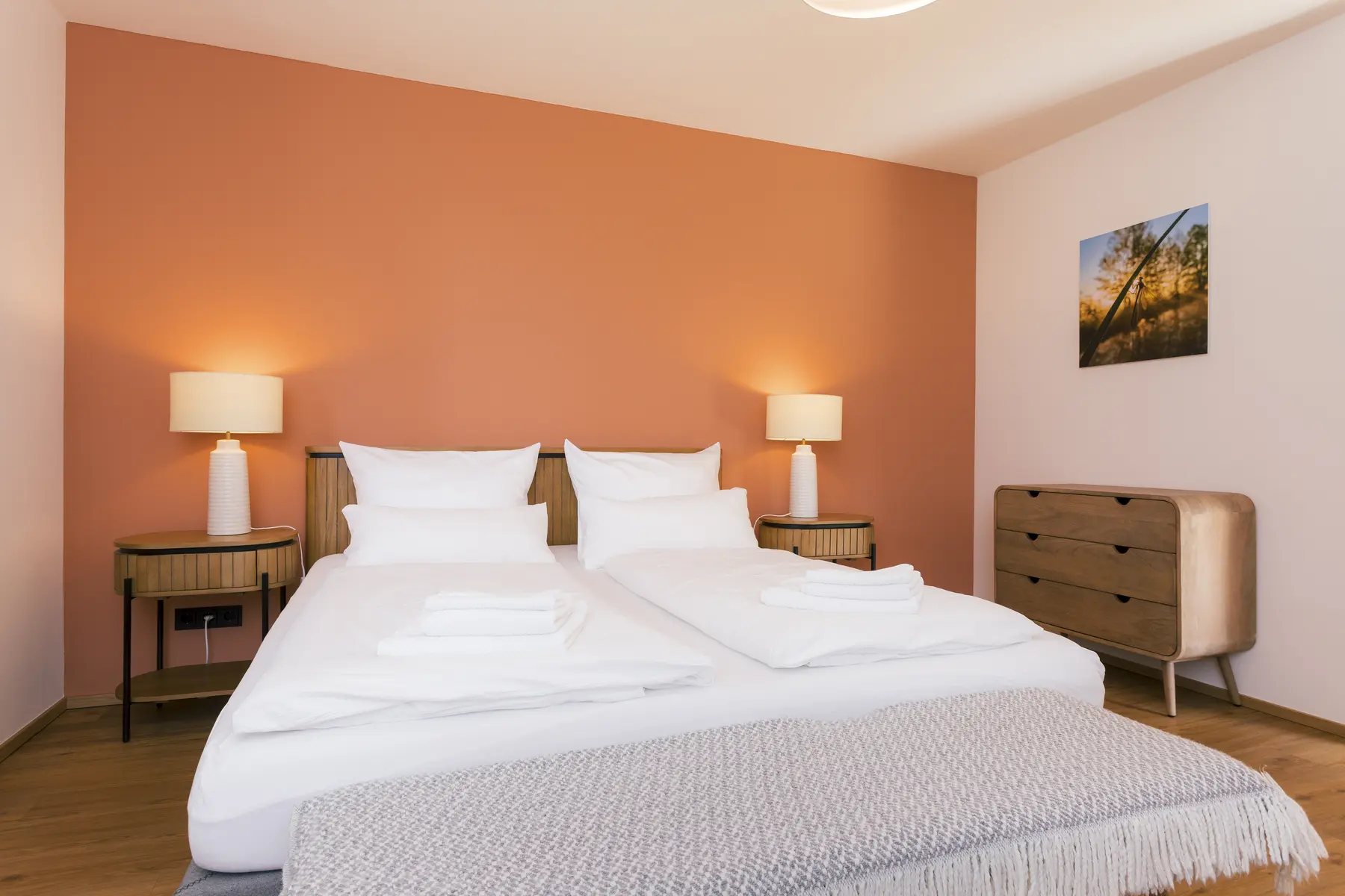 Schlafzimmer der Wohnung Teichblick mit Doppelbett und warmer Wandfarbe