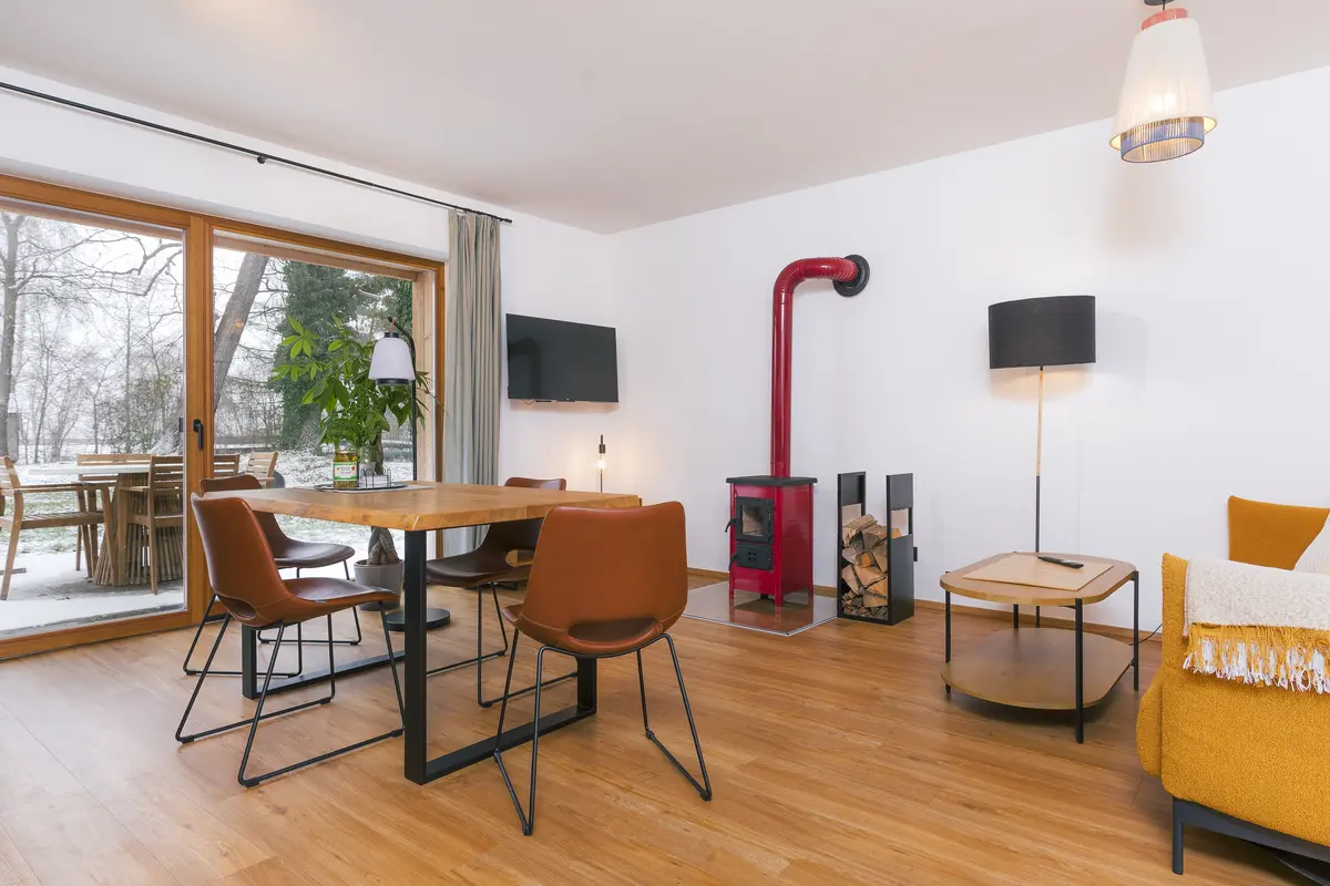 Heller Wohn- und Essbereich der Wohnung Sonnenuntergang mit rotem Kaminofen