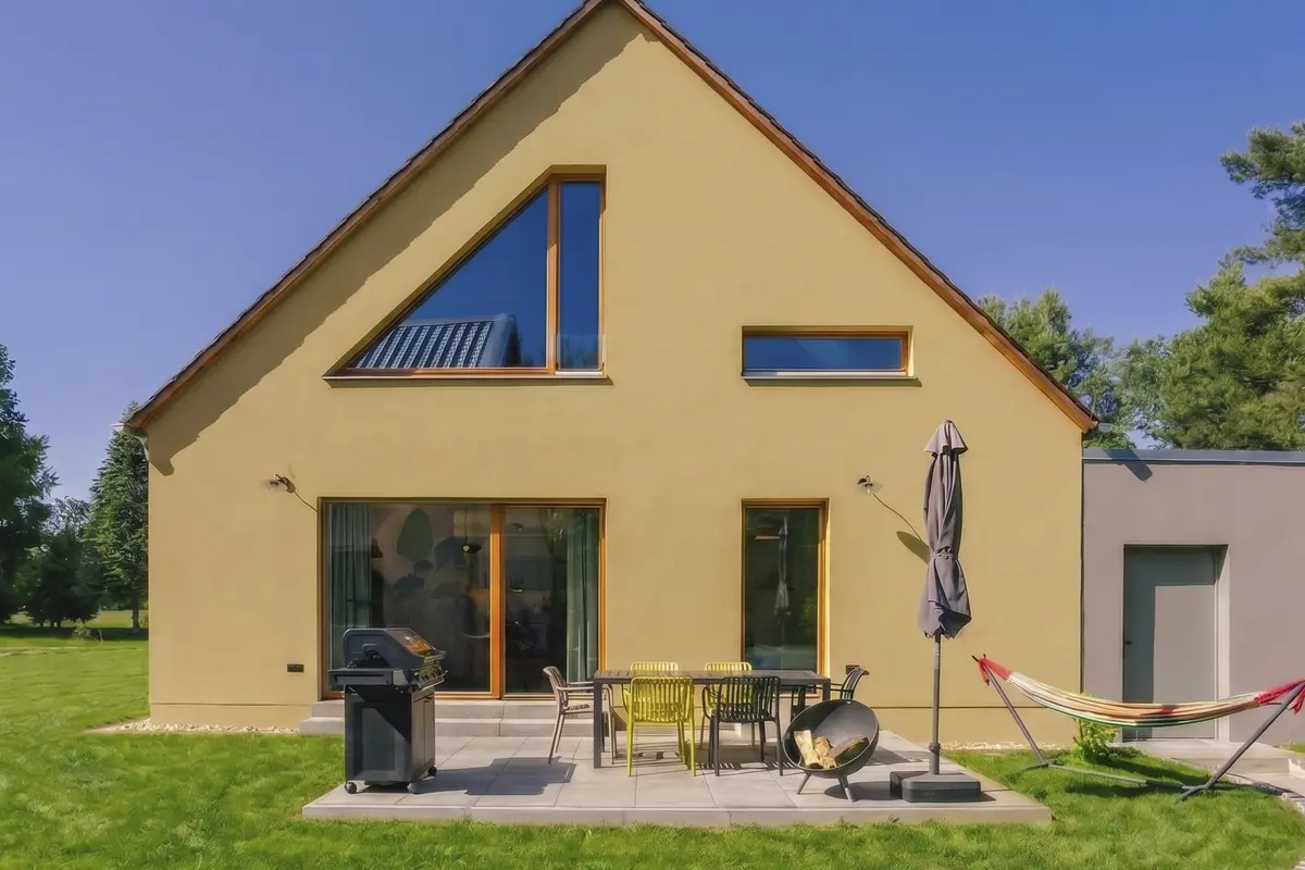 Südterrasse der Wohnung Südseite mit Gasgrill und Hängematte am grünen Garten