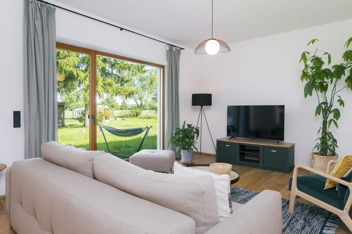 Wohnzimmer der Wohnung Teichblick mit großer Fensterfront zur Terrasse